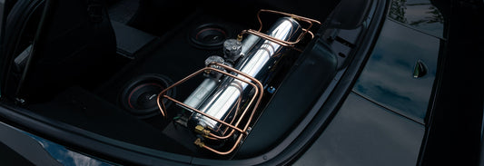 Air tank and VIAIR compressors mounted in the back of a Corvette with intricate copper hard lines.