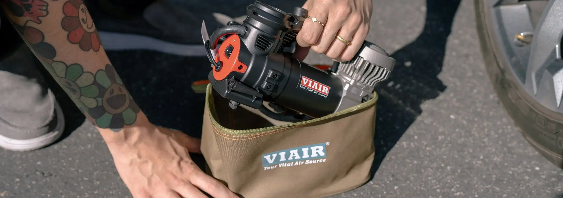 Hands putting air compressor in a bag